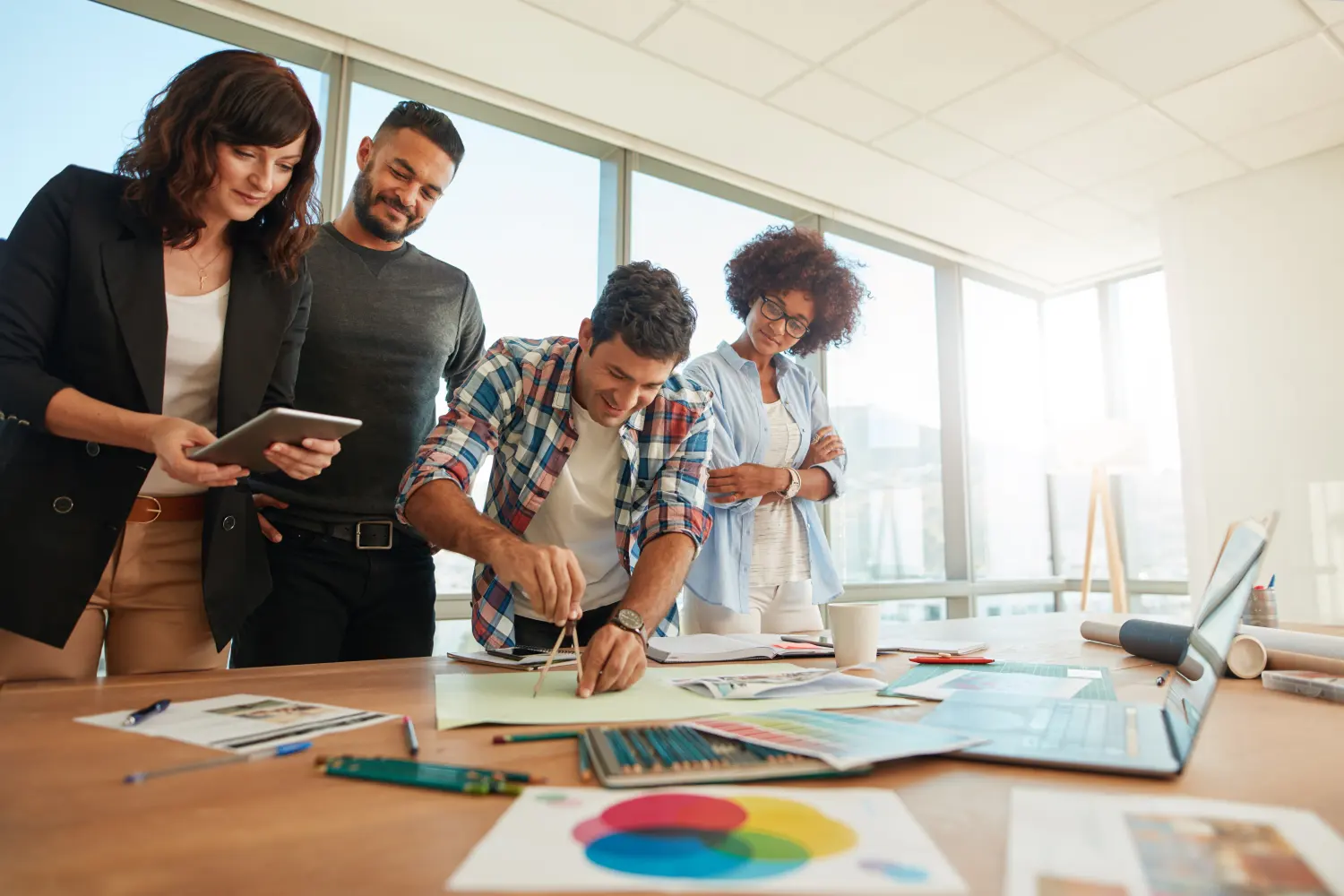 Équipe réunie autour d’une table de travail dans un bureau lumineux