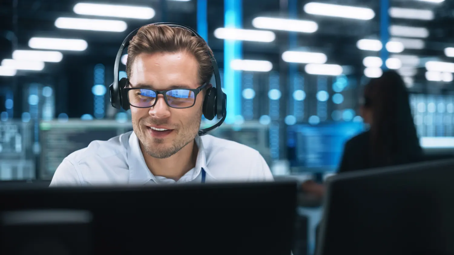 Technicien avec casque devant ses écrans de supervision